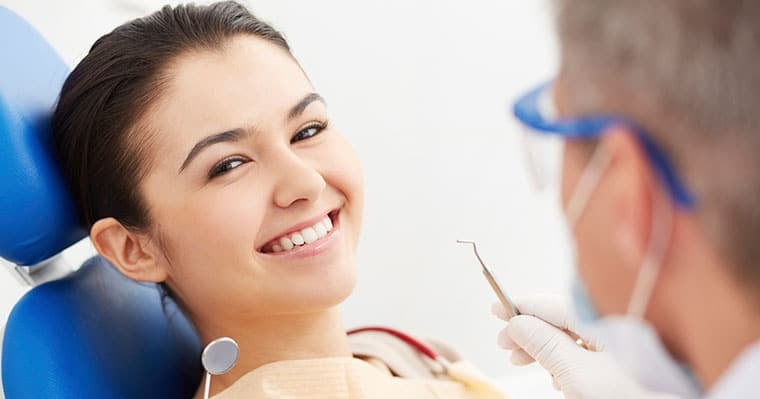 Image of a woman smiling because of sedation dentistry Woman calm and smiling at dentist having solved dental anxiety problems with sedation dentistry