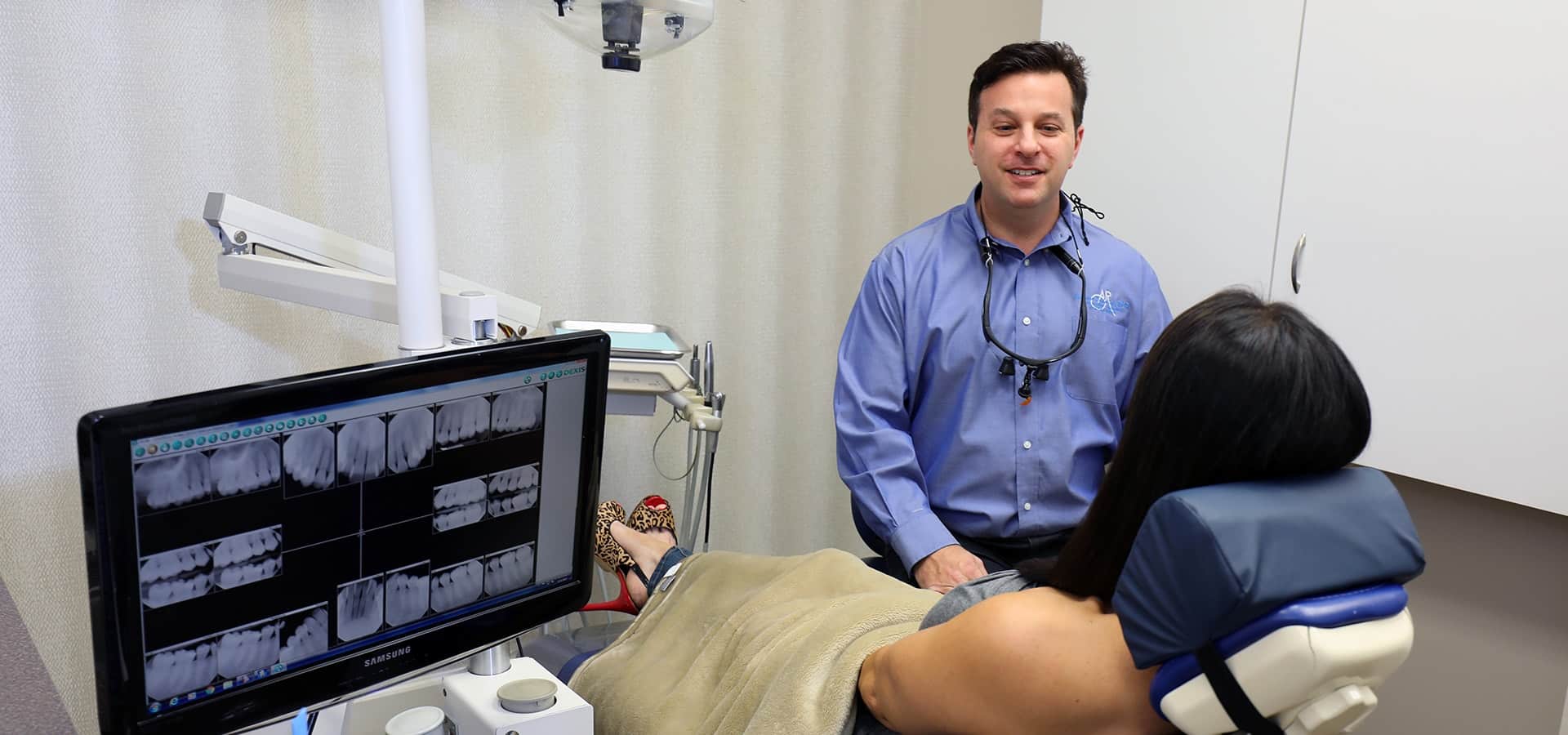 Dentist in Palm Beach Gardens with a patient Your dentist in Palm Beach Gardens speaking with a patient