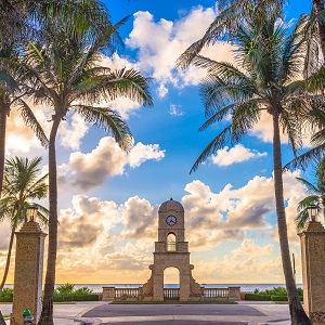 View of monument against blue sky amidst palm trees.