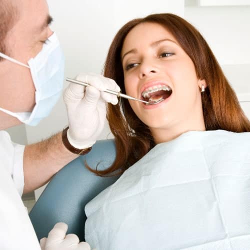 Straighten your teeth and align your jaw with Controlled Arch Braces. Female patient's Controlled Arch Braces being checked