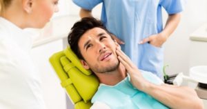 male patient holding his jaw in pain