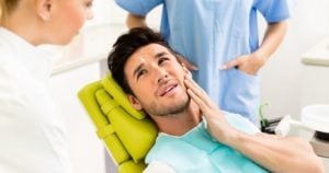 male patient holding his jaw in pain