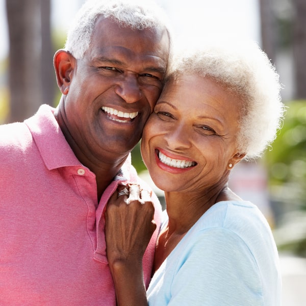 Elderly couple hugging and smiling in a park