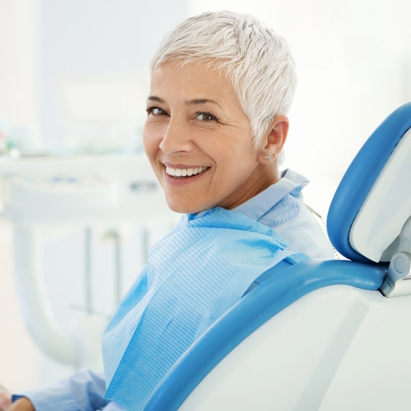 Middle-aged woman in a dental chair smiling