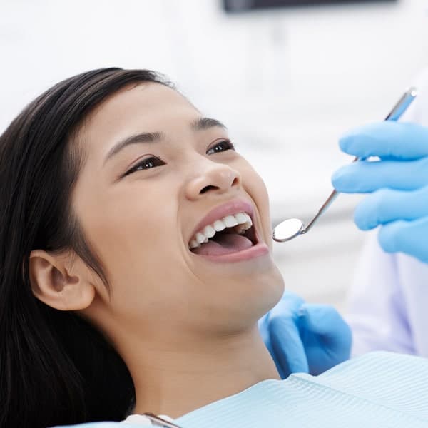 Complete care on your schedule. Woman in a dentist chair with open mouth