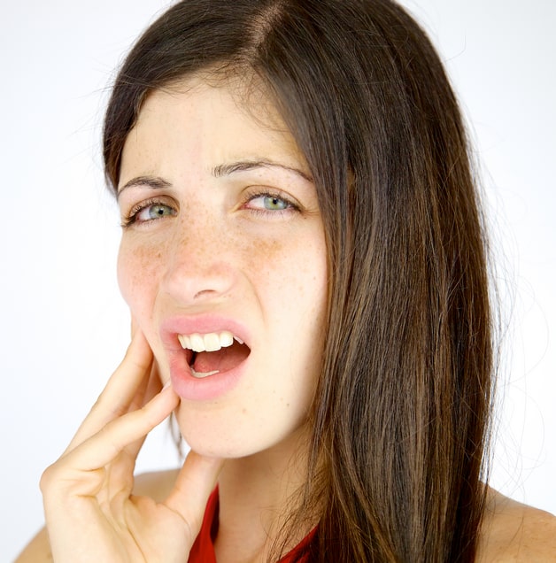 Woman with tooth pain putting her hand on her cheek
