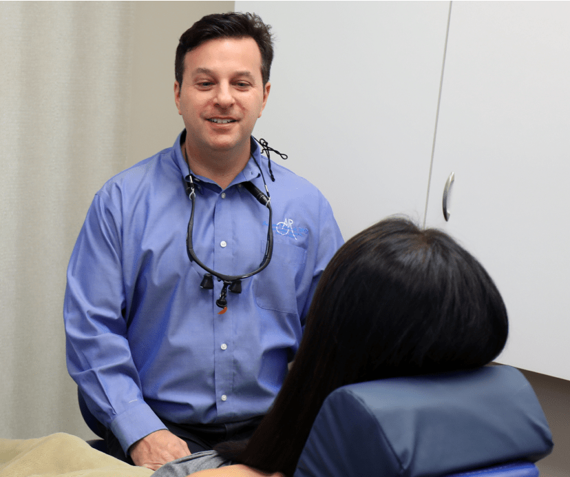 Dr. Rudnick working with his patient and smiling