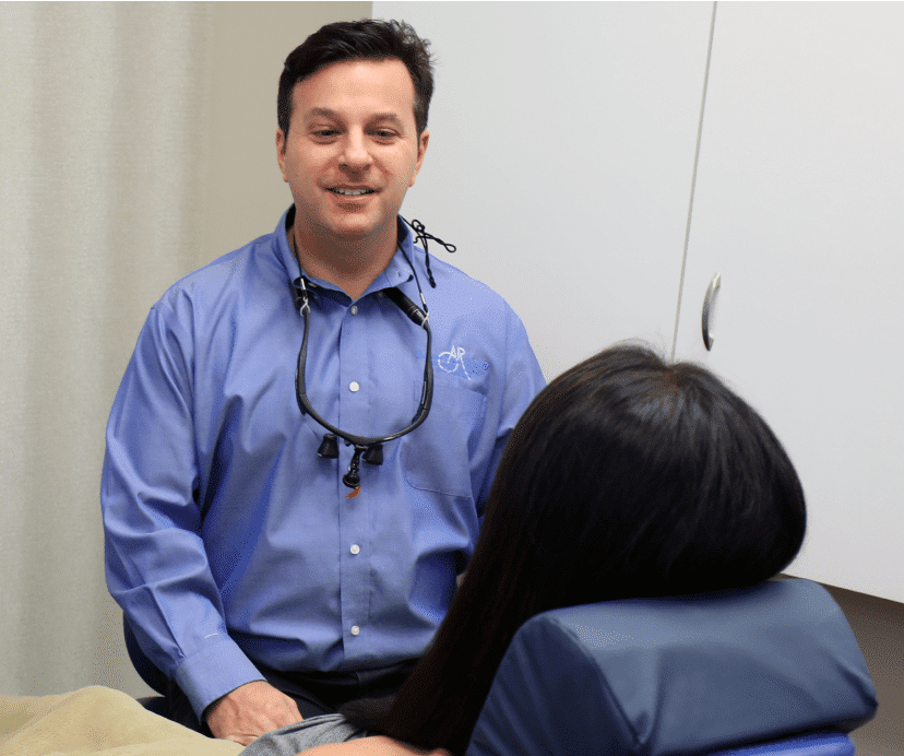 Bringing life to your smile. Dr. Rudnick working with his patient and smiling